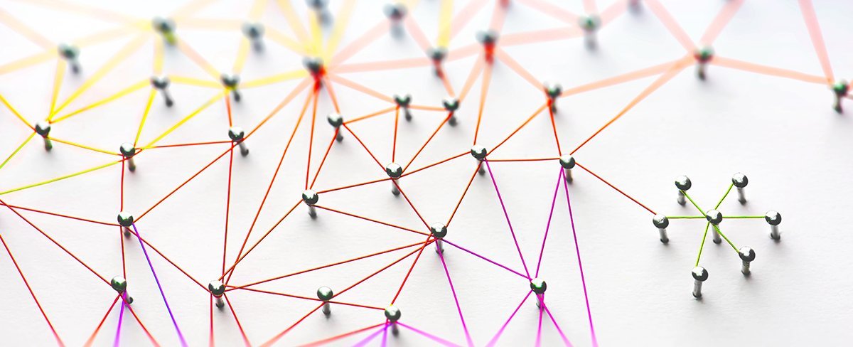 Kleines Netzwerk aus grünen Drähten, das an ein größeres Netzwerk aus roten, orangefarbenen und gelben Drähten auf weißem Hintergrund angeschlossen ist. Kleines Netzwerk aus grünen Drähten, das an ein größeres Netzwerk aus roten, orangefarbenen und gelben Drähten auf weißem Hintergrund angeschlossen ist.